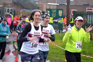 Sara and fellow runners waving at the camera during the race