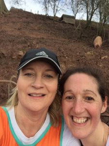 Sara and fellow runner in front of pigs